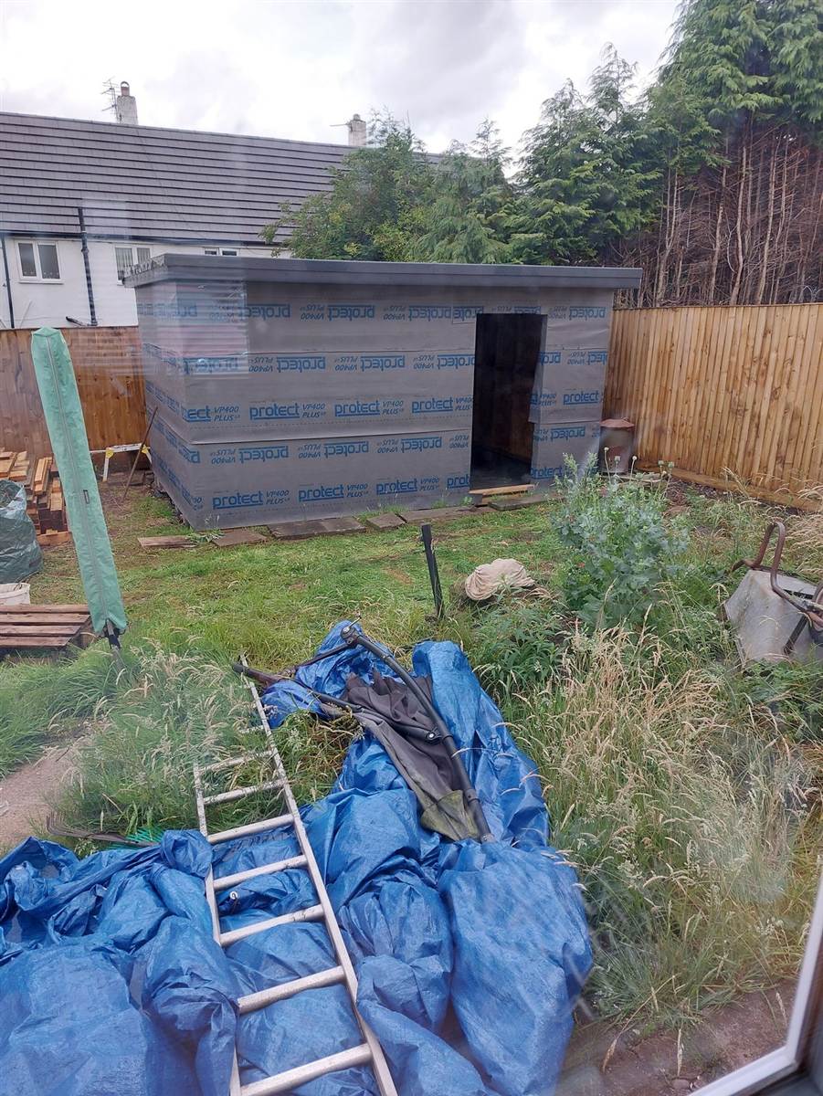 Stud wall frames standing on all sides, door opening framed out, OSB floor deck laid